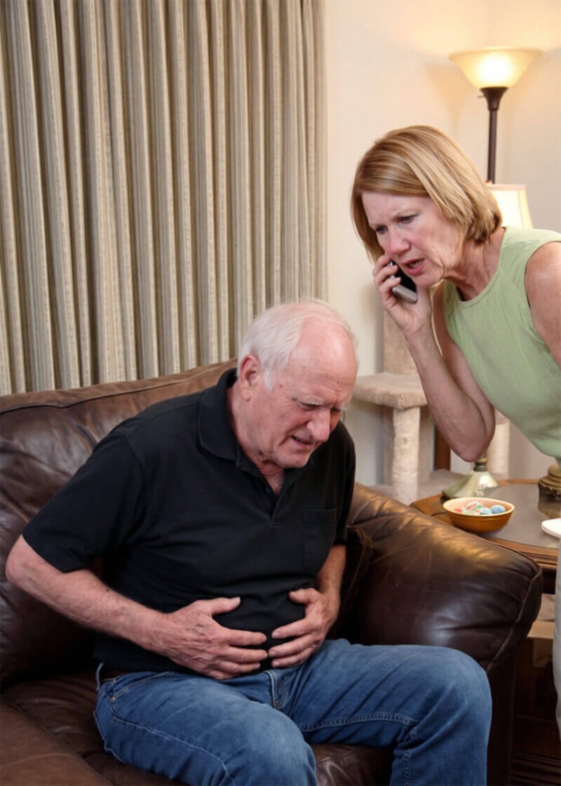 Middle-aged man clutching abdomen in severe pain